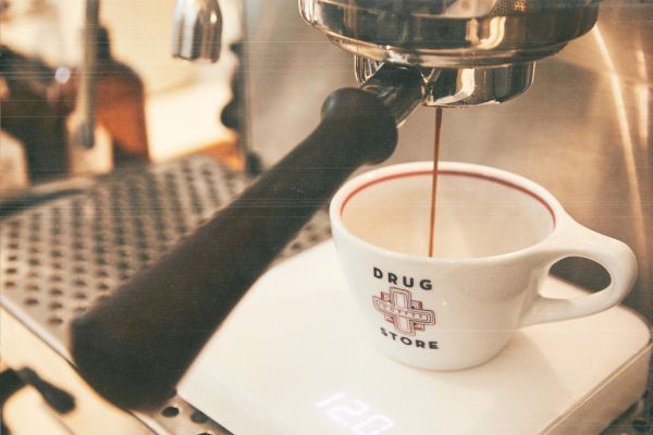 Espresso being brewed into a cup labeled 