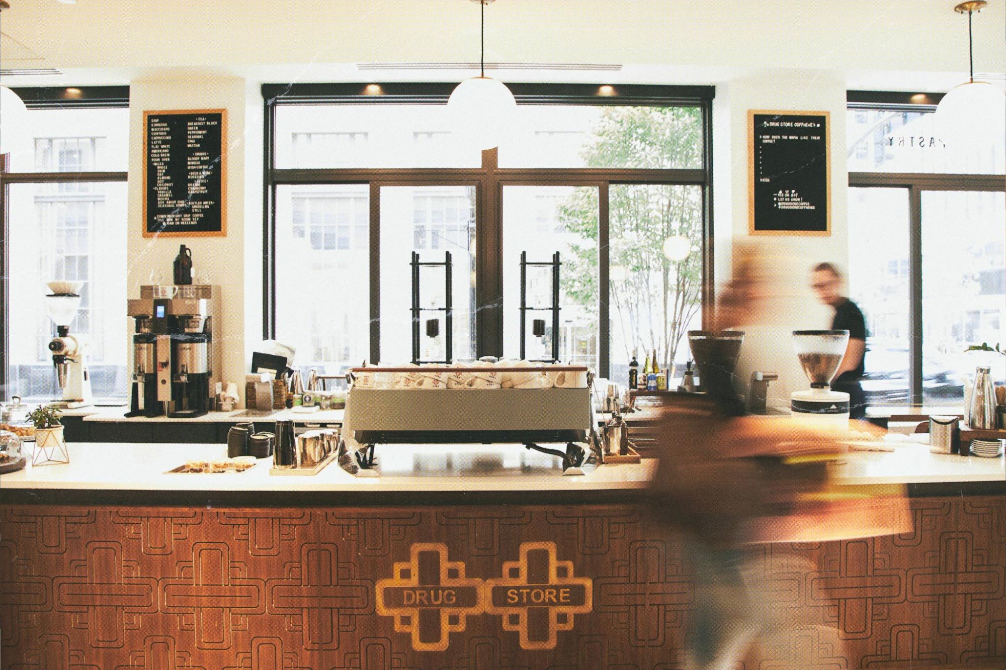 A coffee shop interior with a counter, equipment, and blurred motion.