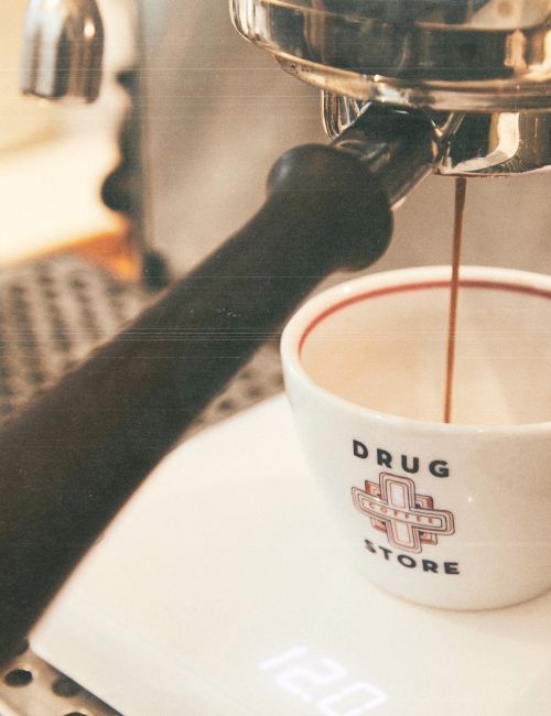 Espresso machine pouring coffee into a cup on a scale.