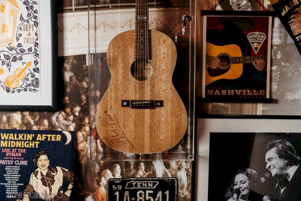 A decorative wall features a wooden guitar, music-themed posters, and a black-and-white photo of musicians, creating a vintage vibe.