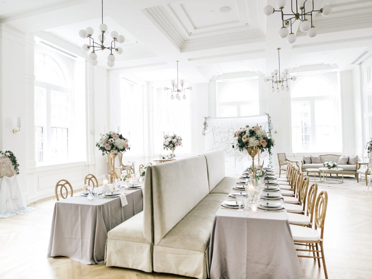 Elegant dining setup with floral centerpieces in a bright, airy room.