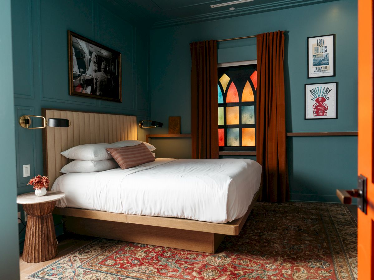 A cozy bedroom with colorful stained glass and a neatly made bed.