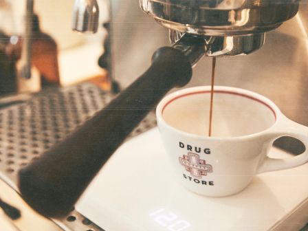 Espresso machine brewing coffee into a white cup.