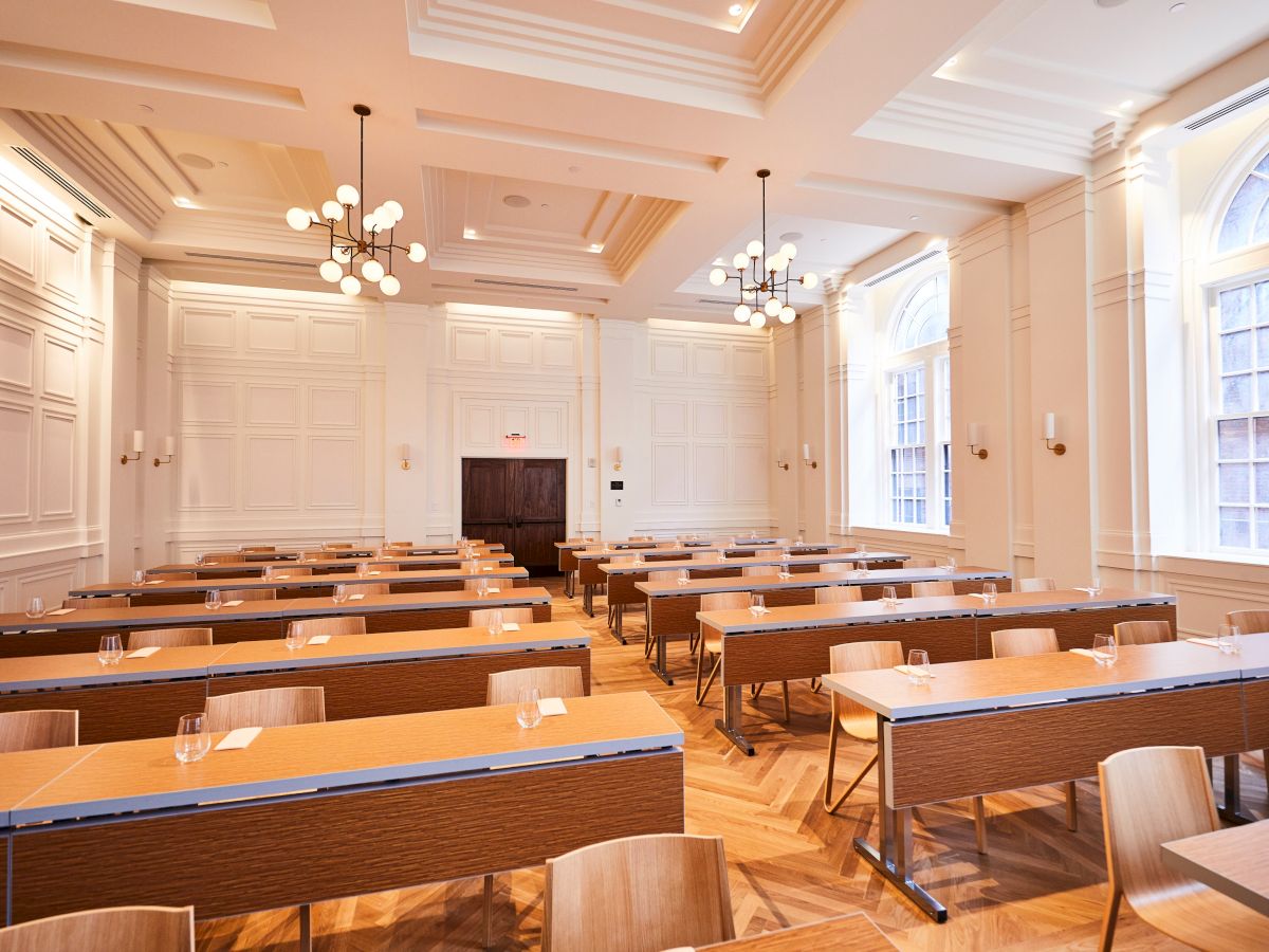 A bright, modern classroom with wooden desks and chairs.