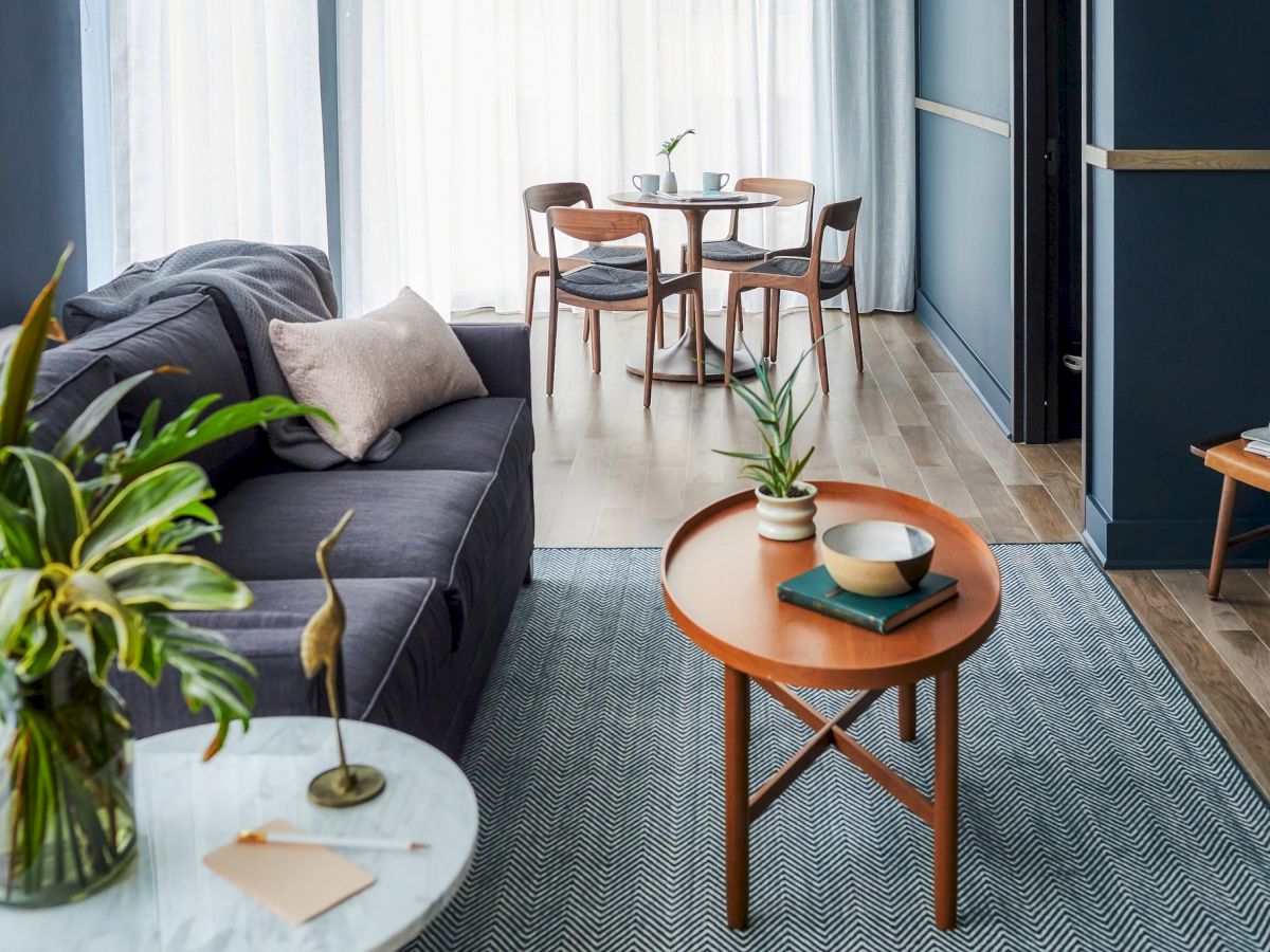 A cozy living room with a sofa, coffee table, and dining set.