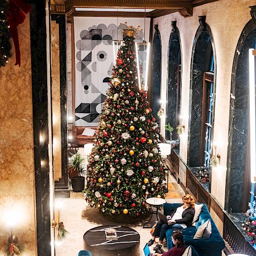 A decorated Christmas tree in a stylish, festive indoor setting.